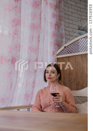 Beautiful young girl sitting at a table in a 137616958