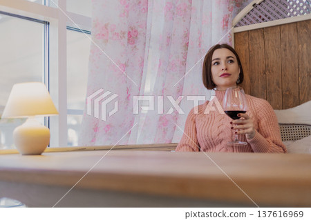 Beautiful young girl sitting at a table in a 137616969