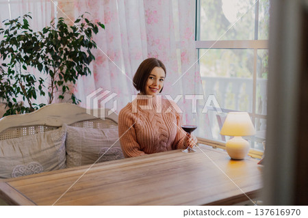 Beautiful young girl sitting at a table in a 137616970