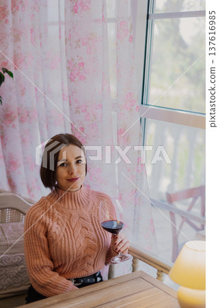 Beautiful young girl sitting at a table in a Beautiful young girl sitting at a table in a 137616985