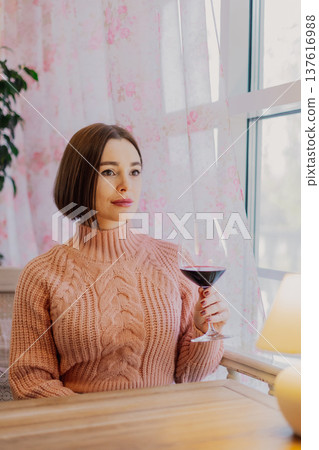 Beautiful young girl sitting at a table in a 137616988