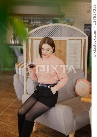 Beautiful young girl sitting at a table in a 137617019