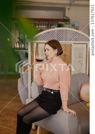 Beautiful young girl sitting at a table in a 137617021