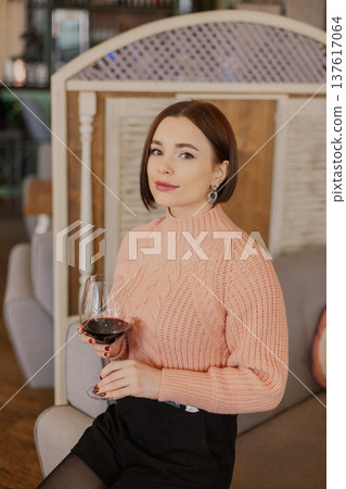 Beautiful young girl sitting at a table in a Beautiful young girl sitting at a table in a 137617064