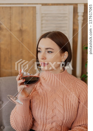 Beautiful young girl sitting at a table in a 137617065