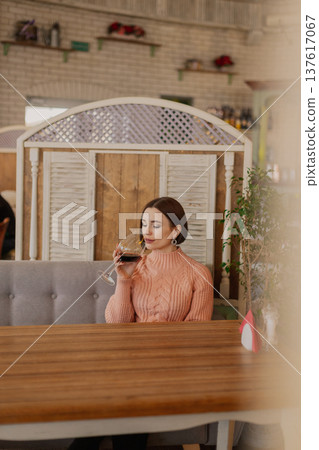 Beautiful young girl sitting at a table in a 137617067