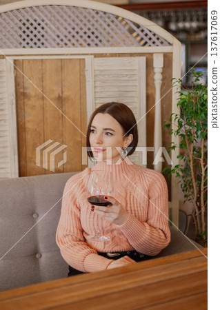 Beautiful young girl sitting at a table in a 137617069
