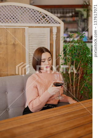 Beautiful young girl sitting at a table in a 137617071