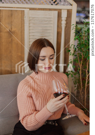 Beautiful young girl sitting at a table in a 137617076