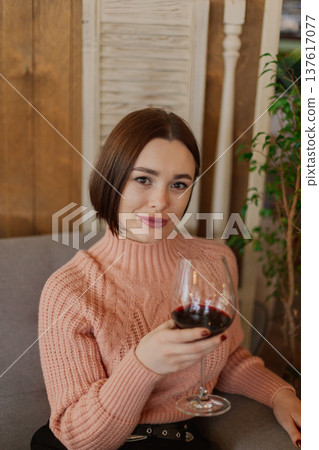 Beautiful young girl sitting at a table in a 137617077