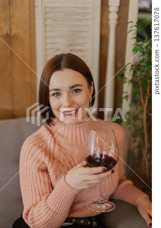 Beautiful young girl sitting at a table in a 137617078