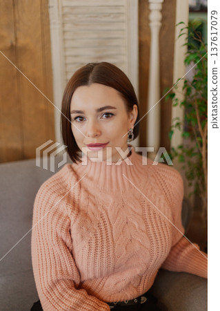 Beautiful young girl sitting at a table in a 137617079