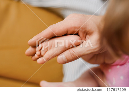 Gentle Touch Of Parent Holding Baby Foot 137617209