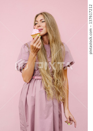 Happy Woman Smelling Cupcake With Pink Frosting Happy Woman Smelling Cupcake With Pink Frosting 137617212