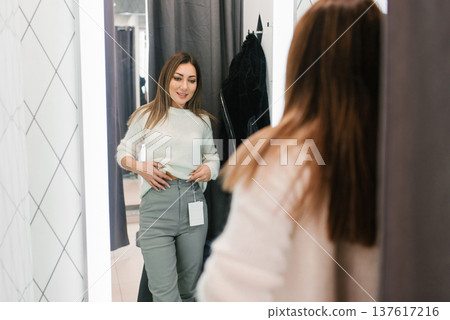 Woman Trying On Jeans In Clothing Store Fitting Area Woman Trying On Jeans In Clothing Store Fitting Area 137617216