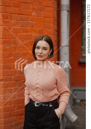 Beautiful young girl posing near red brick wall Beautiful young girl posing near red brick wall 137617272