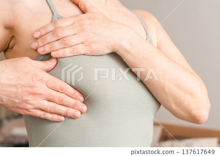 Woman performing breast self-examination, checking for lumps or abnormalities. Concept of health, female anatomy, and oncology prevention Woman performing breast self-examination, checking for lumps or abnormalities. Concept of health, female anatomy, and oncology prevention 137617649