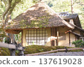 A landscape of an old house with a thatched roof and beautiful round windows bathed in sunlight 137619028