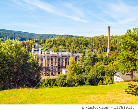 Old textile factory called Klaster, Monastery, with high chimney in summer time, Tanvald, Northern Bohemia, Czech Republic, Europe. 137619133