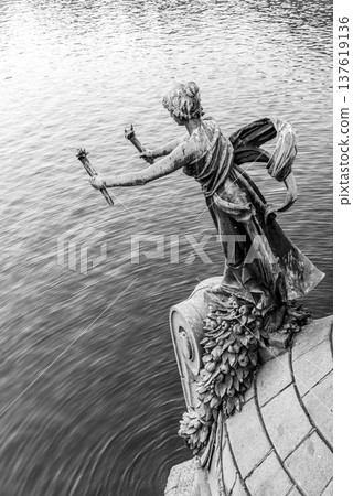 Torch bearer woman figure - bronze decoration of Svatopluk Cech Bridge over Vltava River in Prague, Czech Republic. Black and white image. Torch bearer woman figure - bronze decoration of Svatopluk Cech Bridge over Vltava River in Prague, Czech Republic. Black and white image. 137619136