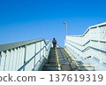 Stairs leading to the blue sky, footbridge and pedestrians 137619319