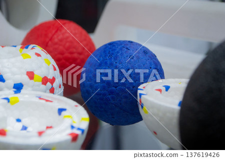 Ball dog toys. Durable foam dog blue red balls close-up. Shape of balls, multi-colored pattern. Object made of material expanded polypropylene EPP, universal foam. New modern industrial technologies. 137619426