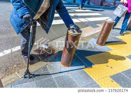 Yokohama cityscape in Japan. Hesitation...steps...fear...elderly man with a cane...a dark shadow sways on the dangerous sidewalk...what is life... Yokohama cityscape in Japan. Hesitation...steps...fear...elderly man with a cane...a dark shadow sways on the dangerous sidewalk...what is life... 137620174