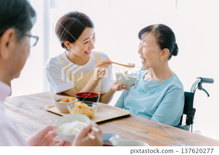 一對老年夫婦和一位護理人員一起用餐 一對老年夫婦和一位護理人員一起用餐 137620277