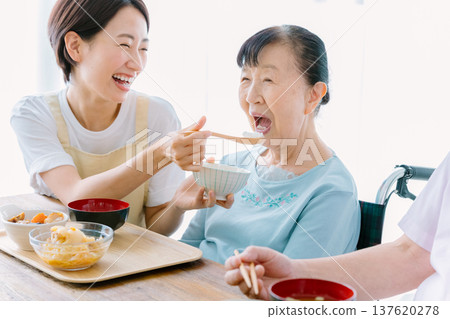 一對老年夫婦和一位護理人員一起用餐 一對老年夫婦和一位護理人員一起用餐 137620278