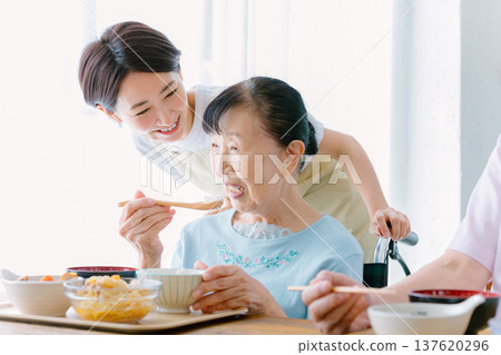 Senior woman having a meal with a caregiver Senior woman having a meal with a caregiver 137620296