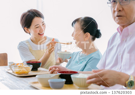Elderly couple having a meal with a caregiver 137620303