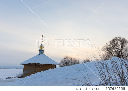 A small wooden Orthodox chapel with a golden dome 137620566