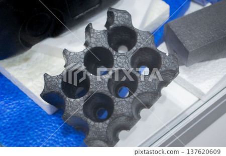 Technical component made of expanded polypropylene EPP. Black object of dense and lightweight EPP, expanded polypropylene material, universal foam. New modern technologies. Industrial manufacturing Technical component made of expanded polypropylene EPP. Black object of dense and lightweight EPP, expanded polypropylene material, universal foam. New modern technologies. Industrial manufacturing 137620609