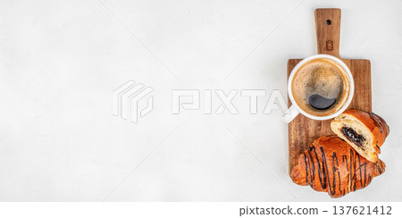 Chocolate croissant with coffee on wooden board top view 137621412