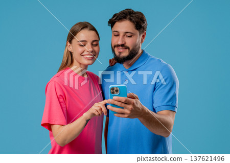 Young Couple Using Mobile Device. Woman Man Watching, Laughing With Smartphone 137621496