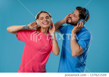 Positive Couple Dancing in headphones. Blue Studio. favorite Music, Dance, Party Positive Couple Dancing in headphones. Blue Studio. favorite Music, Dance, Party 137621509