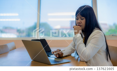 Business decision making and financial analysis at desk. Office work pressure and deadline stress for employees.Mental health at work and professional burnout.Businesswoman working on laptop in office Business decision making and financial analysis at desk. Office work pressure and deadline stress for employees.Mental health at work and professional burnout.Businesswoman working on laptop in office 137621605