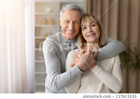 Happy senior couple embracing and smiling at camera at home 137621616