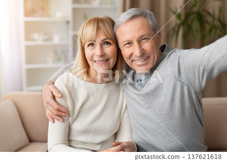 Portrait of smiling senior couple taking selfie together on sofa at home Portrait of smiling senior couple taking selfie together on sofa at home 137621618