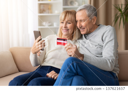 Senior couple using smartphone and credit card for online shopping at home Senior couple using smartphone and credit card for online shopping at home 137621637