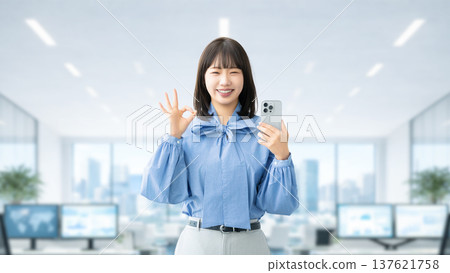一位年輕女子/女商人手持智慧型手機，擺出「OK」的手勢 137621758