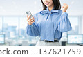 A young woman/businesswoman looking at her smartphone and making a fist pump A young woman/businesswoman looking at her smartphone and making a fist pump 137621759