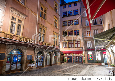 Lyon, france. December 29, 2023. Historic vieux lyon cobblestone street at dusk, traditional french buildings, glowing bistros and lamps creating romantic evening atmosphere Lyon, france. December 29, 2023. Historic vieux lyon cobblestone street at dusk, traditional french buildings, glowing bistros and lamps creating romantic evening atmosphere 137621919