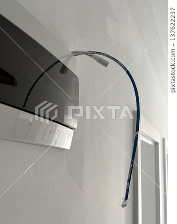 Ethernet cable protruding from wall for internet installation in modern home interior setup 137622237