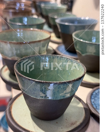 Ceramic cups with blue glaze on display for sale, offering a rustic kitchenware concept 137622240