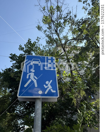 Traffic sign indicating children playing near bus stop with trees in background Traffic sign indicating children playing near bus stop with trees in background 137622281