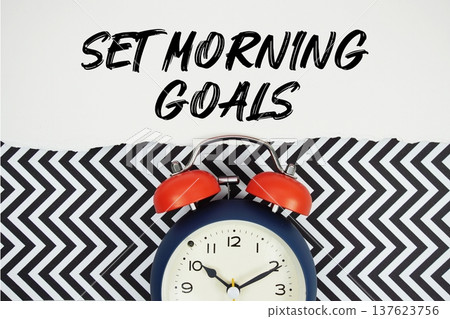 Set Morning Goals text written on paper rip with alarm clock flat lay on black chevron background Set Morning Goals text written on paper rip with alarm clock flat lay on black chevron background 137623756
