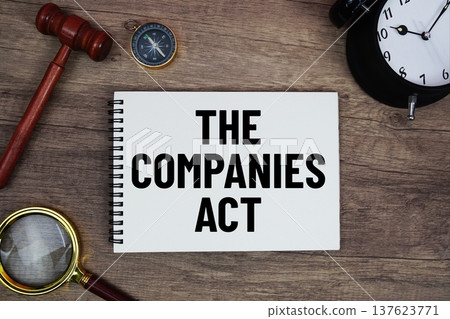 The Companies Act message written on notepad with alarm clock, wood gavel and magnifying glass flat lay on wooden background 137623771
