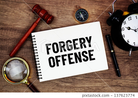 Forgery Offense message written on notepad with alarm clock, wood gavel and magnifying glass flat lay on wooden background Forgery Offense message written on notepad with alarm clock, wood gavel and magnifying glass flat lay on wooden background 137623774