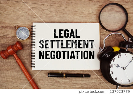 Legal Settlement Negotiation message written on notepad with alarm clock, wood gavel and magnifying glass flat lay on wooden background 137623779